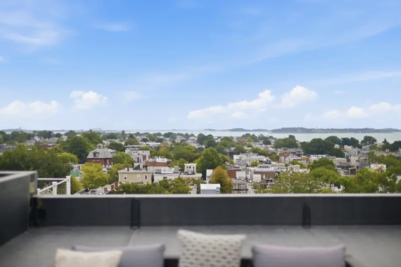 View across South Boston rooftops to the water from the private roof deck at Residence 3, 421 East Sixth, South Boston