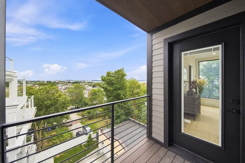 Covered bedroom deck with metal railing overlooking South Boston at Residence 4, 421 East Sixth, South Boston