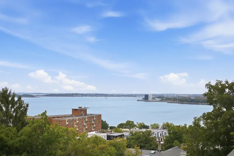 Panoramic view of Boston Harbor and South Boston rooftops from the private roof deck at Residence 4, 421 East Sixth, South Boston