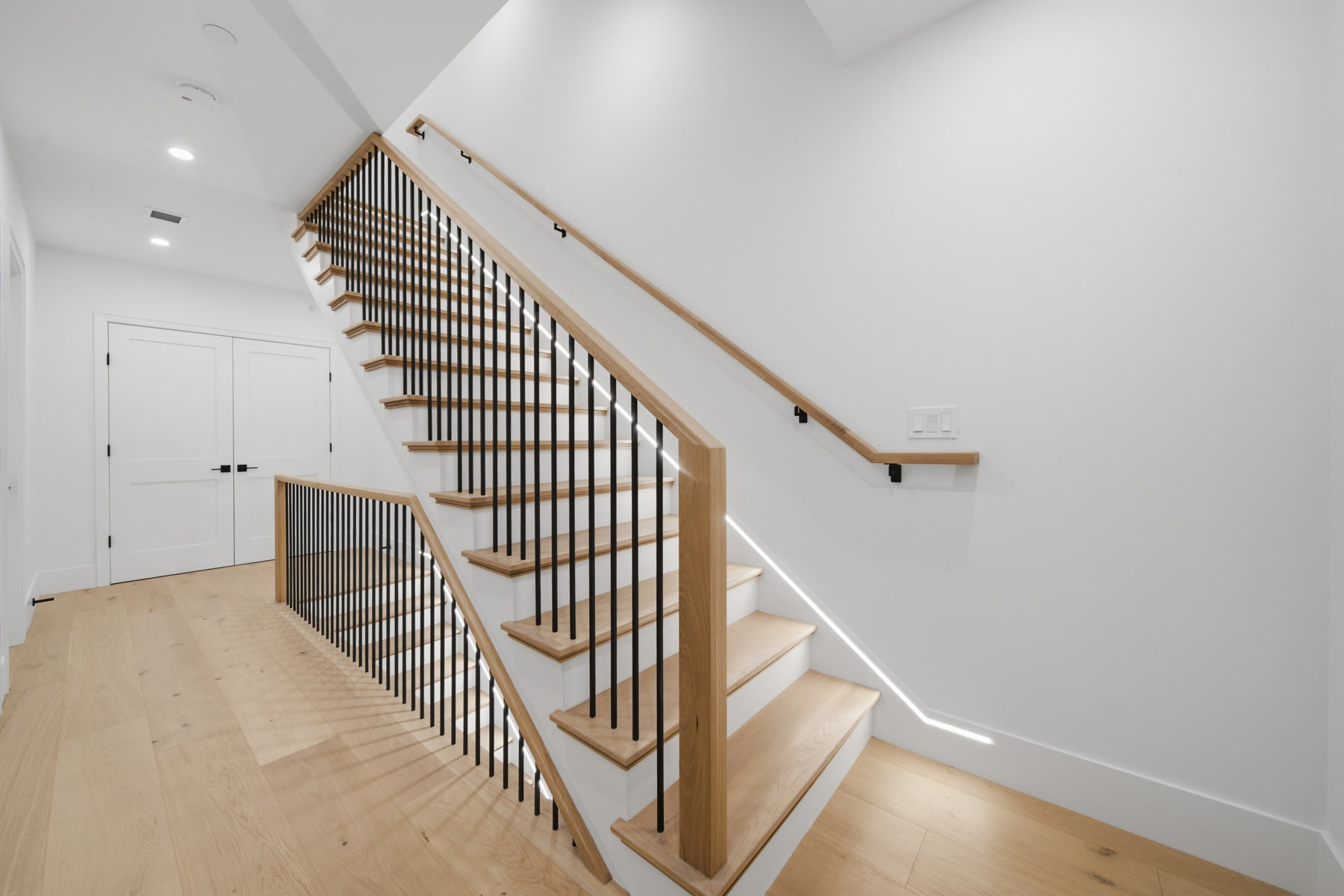 Finished oak stair with under-stair lighting at Residence 4, 421 East Sixth